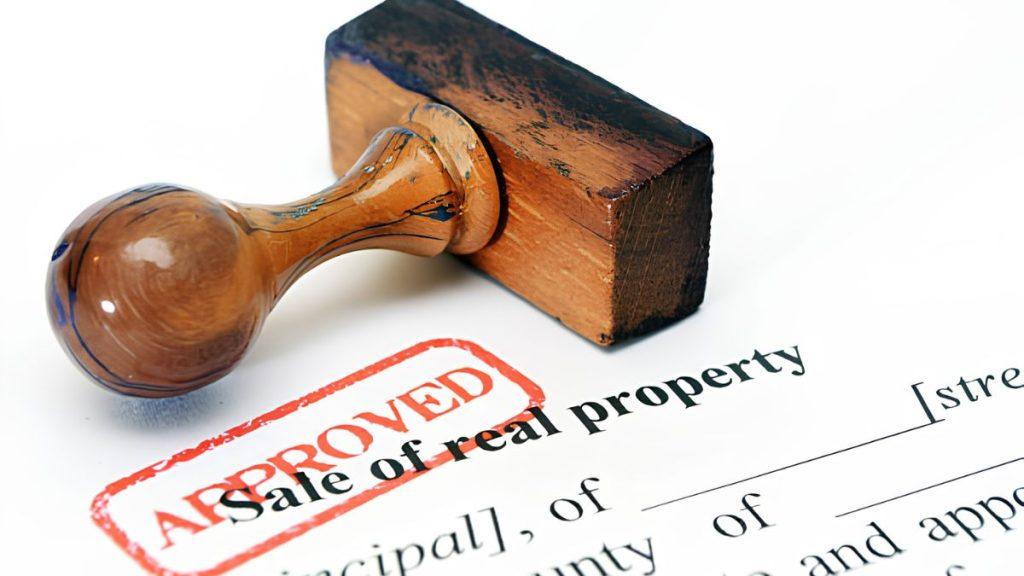 Red 'APPROVED' stamp on a real property sale document.